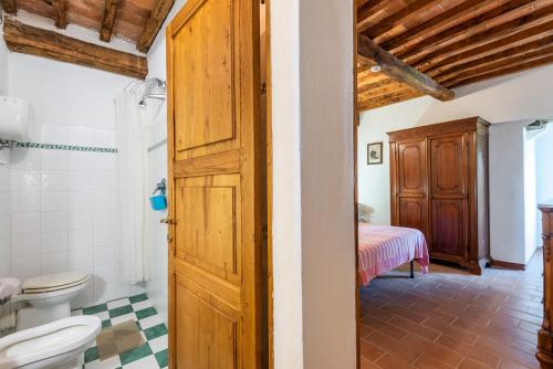 a bathroom with a toilet and a bed in a room at Appartamento Nobile Murlo in Murlo