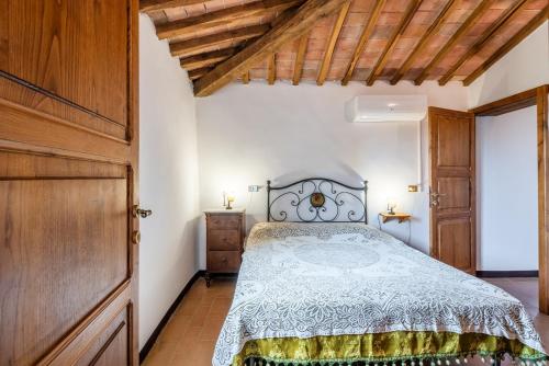 a bedroom with a bed and a wooden door at Appartamento Brunello Murlo in Murlo