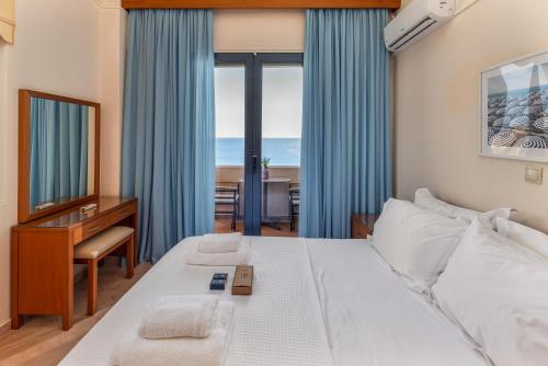 a bedroom with a bed and a desk with a mirror at Royal Bay Villa Bali in Bali