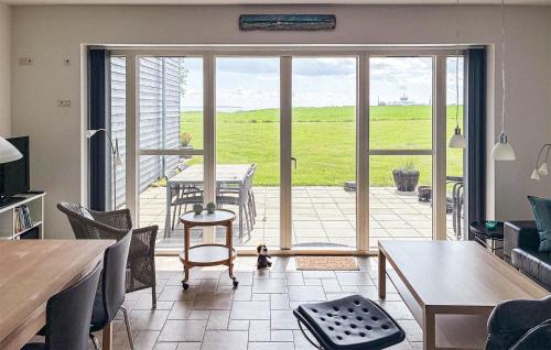 a living room with a large glass door with a table and chairs at 2 Bedroom Nice Apartment In Samsø in Ballen
