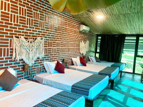 a room with three beds and a brick wall at Nang Villa HA in Yên Bài
