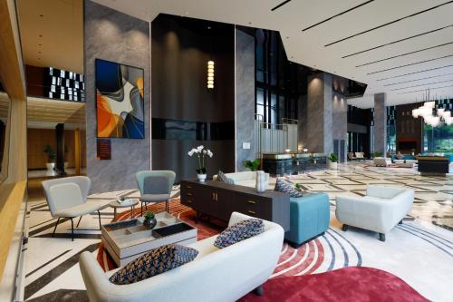 a lobby with couches and chairs in a building at Harris Hotel & Convention Serpong in Tangerang