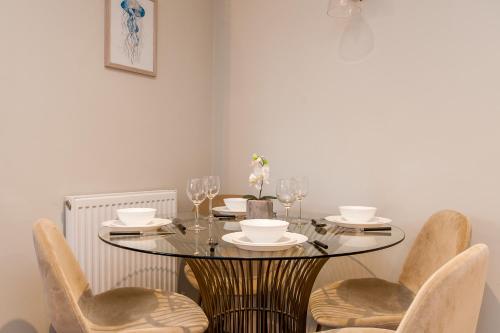 a dining room with a table with chairs and glasses at Marsh House - Modern Apartment With Hot Tub in Whitstable
