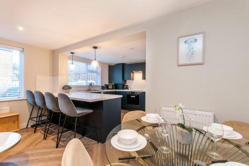 a kitchen and living room with a table and chairs at Marsh House - Modern Apartment With Hot Tub in Whitstable