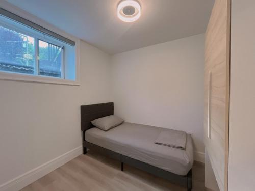 a small bed in a room with a window at Claire House in Vancouver