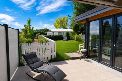 a patio with black chairs and a white fence at TraumBlick in Rimsting