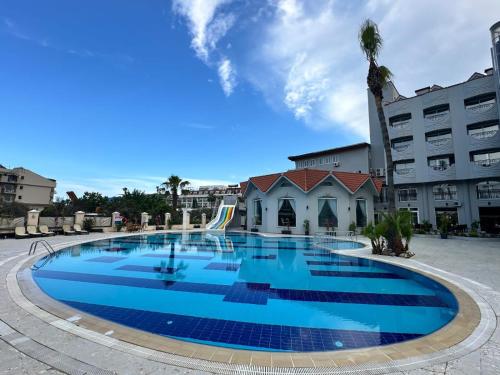 a large blue pool in front of a building at Çamyuva Luna Hotel in Kemer