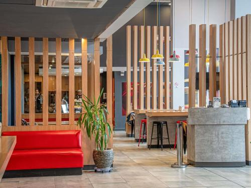 a lobby with a red couch and a table at ibis Iquique in Iquique