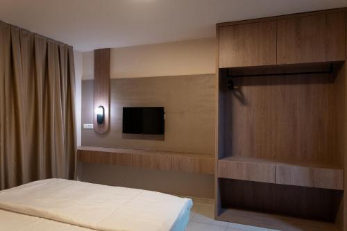a bedroom with a bed and a tv on a wall at Dremka Guesthouse Peshtani in Ohrid