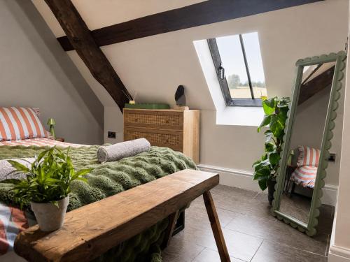 a bedroom with a bed and a wooden bench at The Eaves - Pen Y Fan Views in Brecon