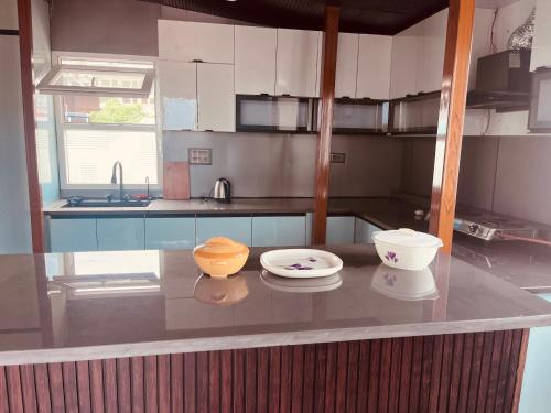 a kitchen with two bowls and plates on a counter at Soar Serenity Homes in Pithorāgarh