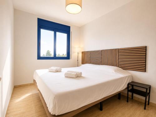 a bedroom with a large bed with two towels on it at Casa 3 hab, piscina, playa, parking, L'Ampolla in L'Ampolla