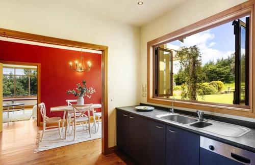 a kitchen with a sink and a dining room with a table at Peninsula Paradise in Dunedin