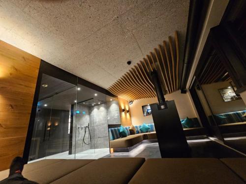 a living room with a couch and a glass wall at rocking home in Aschau