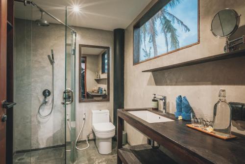 a bathroom with a shower and a toilet and a sink at Mangroove Bay Boutique Hostel in Banyuwedang
