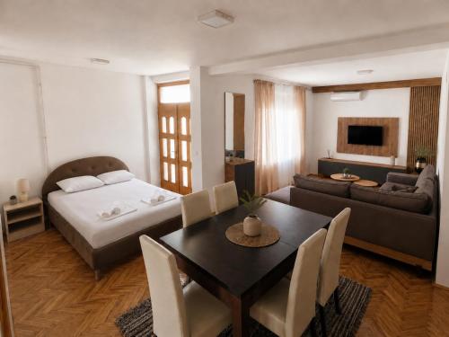 a living room with a bed and a table and chairs at Prenoćište-Vila Tasić in Vranje