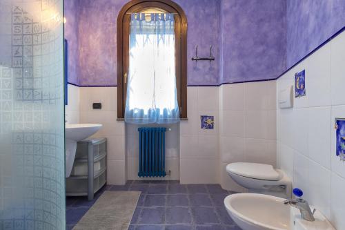 a bathroom with a sink and a toilet and a window at Villa Luna e' Pedra - Suites Esclusive in Villa con Vista sulla Baia di Alghero e Piscina, Jacuzzi privata in Alghero