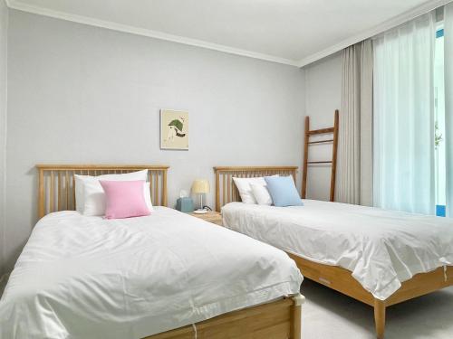 two beds sitting next to each other in a bedroom at Mapo Panorama Stay in Seoul