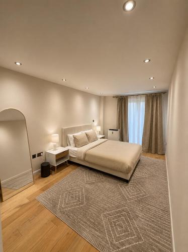a bedroom with a large bed and a rug at Spacious 3BR Lancaster Gate Near Hyde Park in London