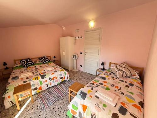 a bedroom with two beds and a refrigerator at Casa di Sunshine in Ragusa
