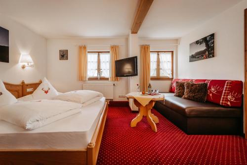 a living room with two beds and a couch at Gästehaus Walserheimat in Riezlern