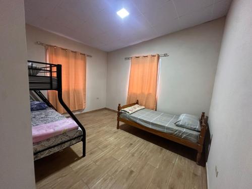 a bedroom with two bunk beds and a wooden floor at California, Volcán, casa completa in Nueva California