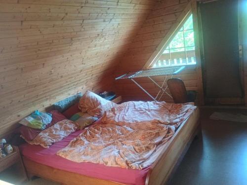 an unmade bed in a room with a window at Holzhaus Rheingoldstraße 49a in Urbar
