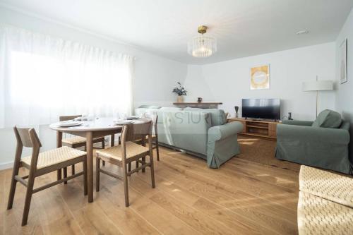 a living room with a table and chairs and a couch at Los Sauces By Silastur in Villaviciosa
