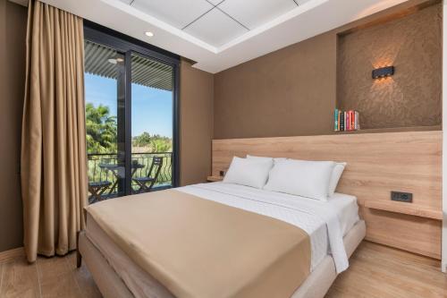 a bedroom with a large bed and a balcony at Demirel Suites Antalya-Lara Plajlar ve Havalimanına Yakın in Lara