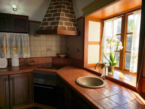 a kitchen with a counter with a sink and a window at Fide in Tijarafe