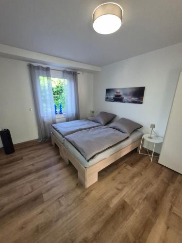 a bedroom with a large bed in a room with wooden floors at FeWo Carolina in Püttlingen