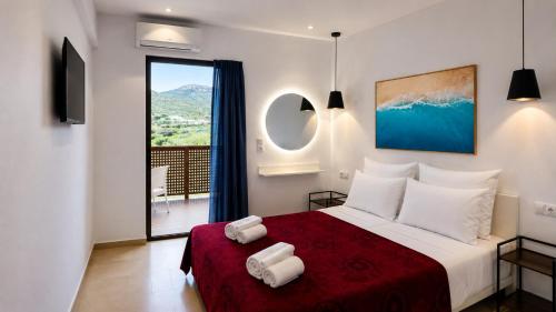 a bedroom with a large bed with a red blanket at Oasis Apartments & Rooms in Plakias