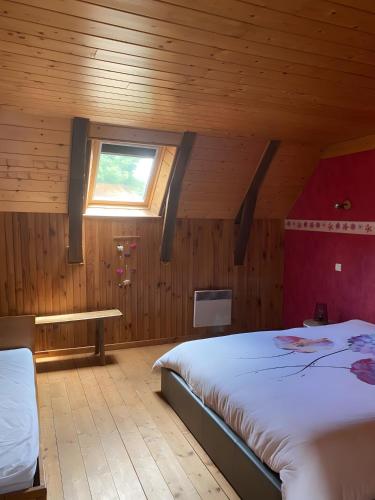 a bedroom with a large bed and a window at La Ruche - Coquelicot in Mauriac