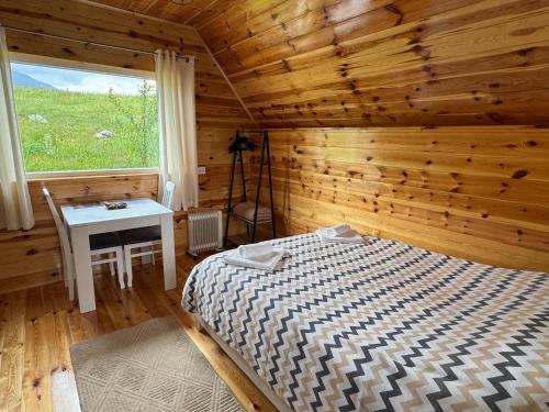 a bedroom with a bed and a window in a cabin at Village Cottage in Žabljak