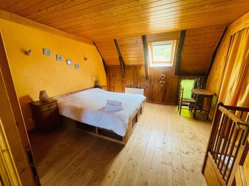 a bedroom with a bed in a wooden house at Gîte La Ruche in Mauriac