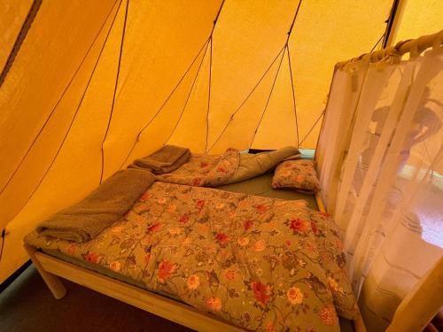 a bedroom with a bed and pillows in a tent at Västeräng Glamping in Lillandet