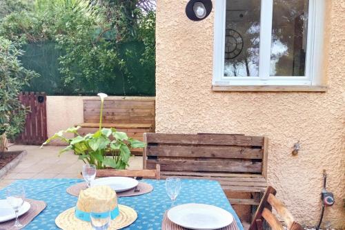a table with plates and glasses on a blue table cloth at Apartment with a large tree-lined terrace in Sanary-sur-Mer
