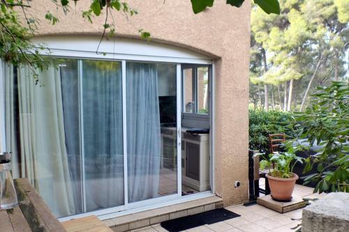 a sliding glass door on the side of a house at Apartment with a large tree-lined terrace in Sanary-sur-Mer