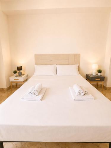 a large white bed with two towels on it at Harbor Elegance Estate in Milazzo