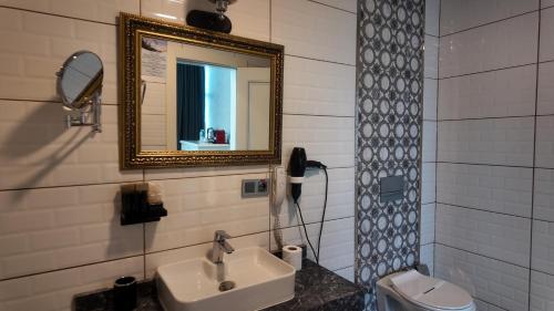 a bathroom with a sink and a mirror and a toilet at Resun Hotel in Ankara