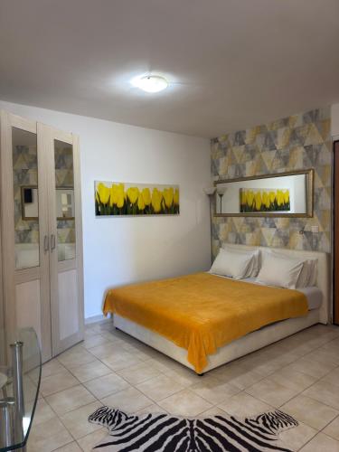 a bedroom with a large bed with orange sheets at Location Apartments in Herceg-Novi