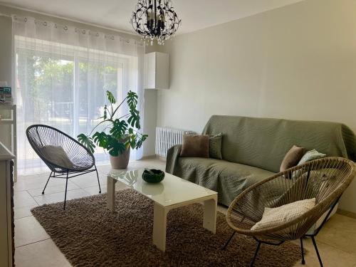 a living room with a couch and chairs and a table at Corps de ferme à 50min de Lyon in Moissieu-sur-Dolon