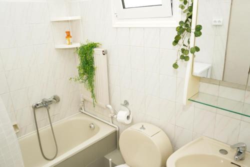 a bathroom with a toilet and a tub and a sink at Galini Cosy Home in Asprovalta