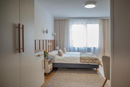 a bedroom with a bed and a window at Pokoje ABC Centrum in Ustka