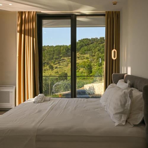 a bedroom with a large bed with a large window at Villa 30 Luxury Place Vlore in Fshati i Ri