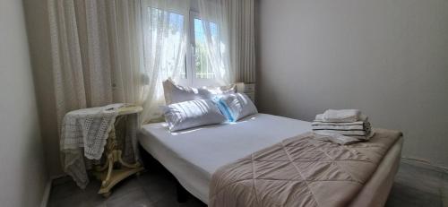 a small bedroom with a bed and a window at Galini Cosy Home in Asprovalta