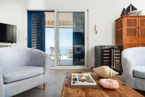 a living room with two chairs and a coffee table at Casa Mamà private access to sea in Santa Flavia