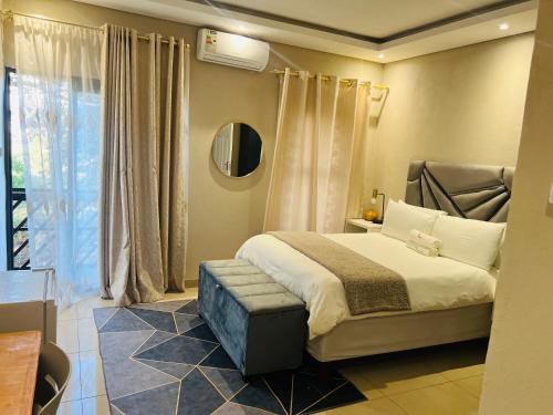 a bedroom with a large bed and a window at Falaza Lodge Jozini in Bhokweni