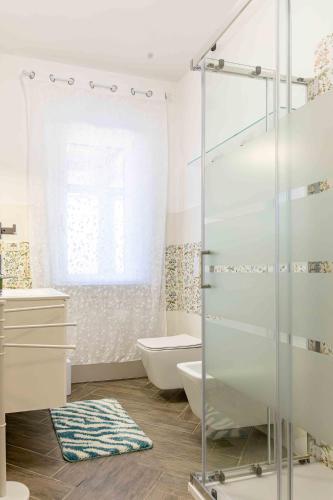 a bathroom with a glass shower and a toilet at Casa Turchese in Alghero