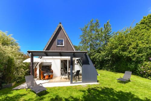 a small cottage with a pitched roof on a lawn at Ferienhaus Windspiel in Neuharlingersiel